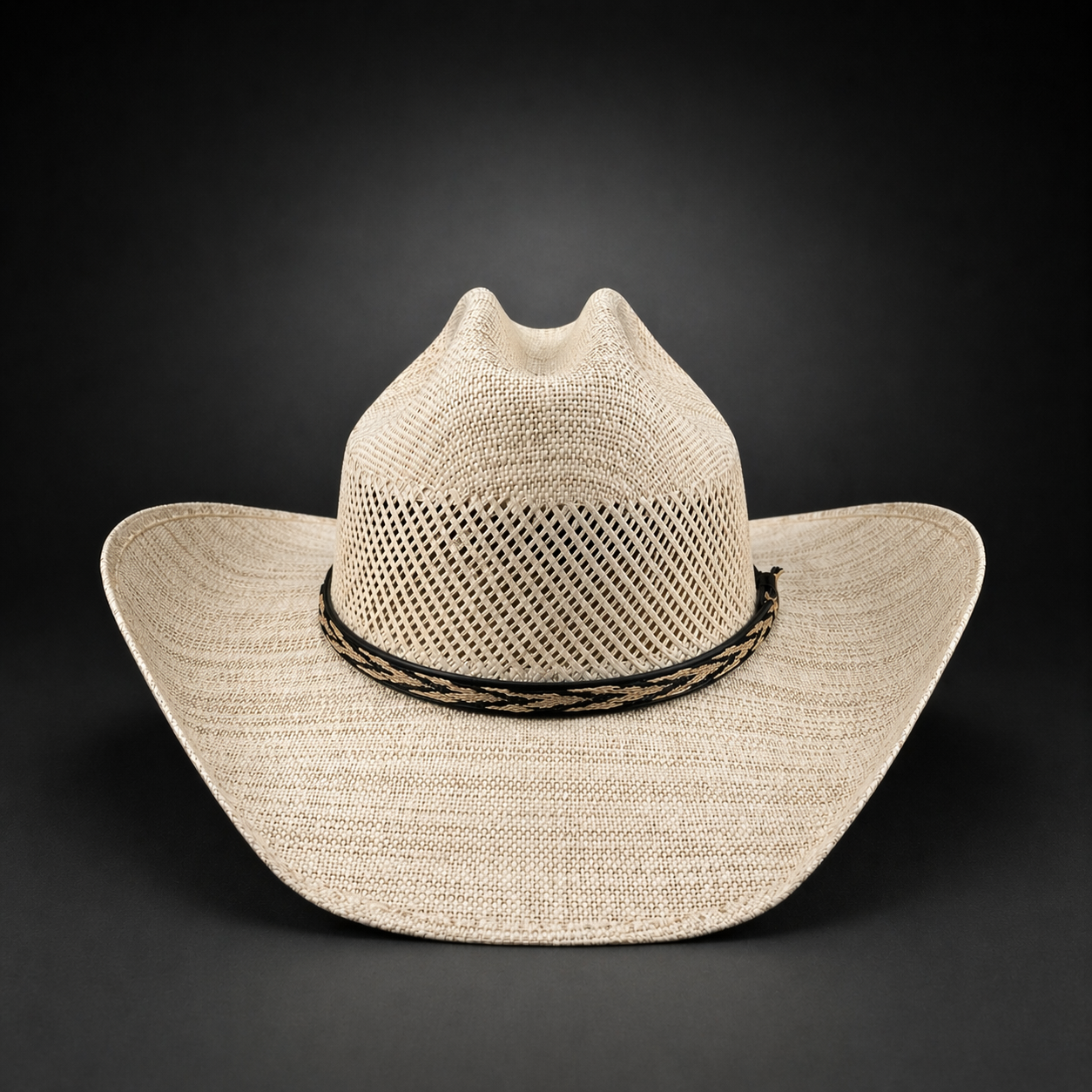 Beige cowboy hat with a black band on a dark background